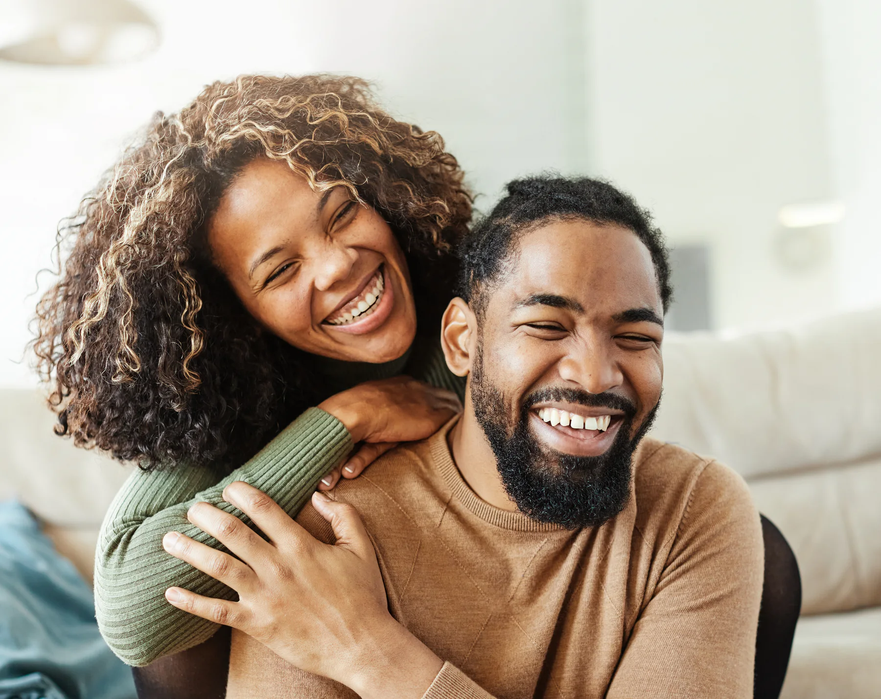 A smiling couple embracing at home