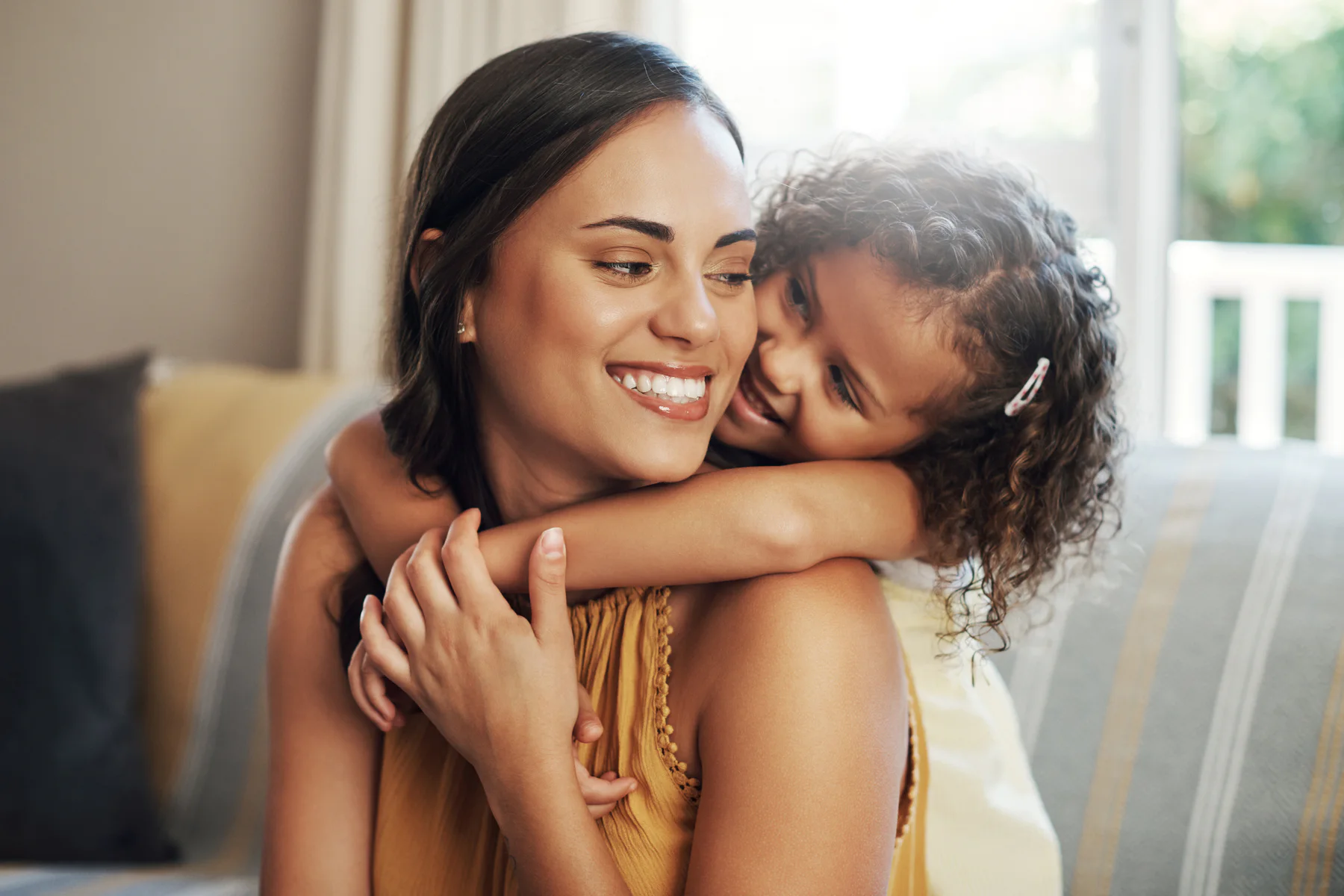 A mother and daughter smiling together at home