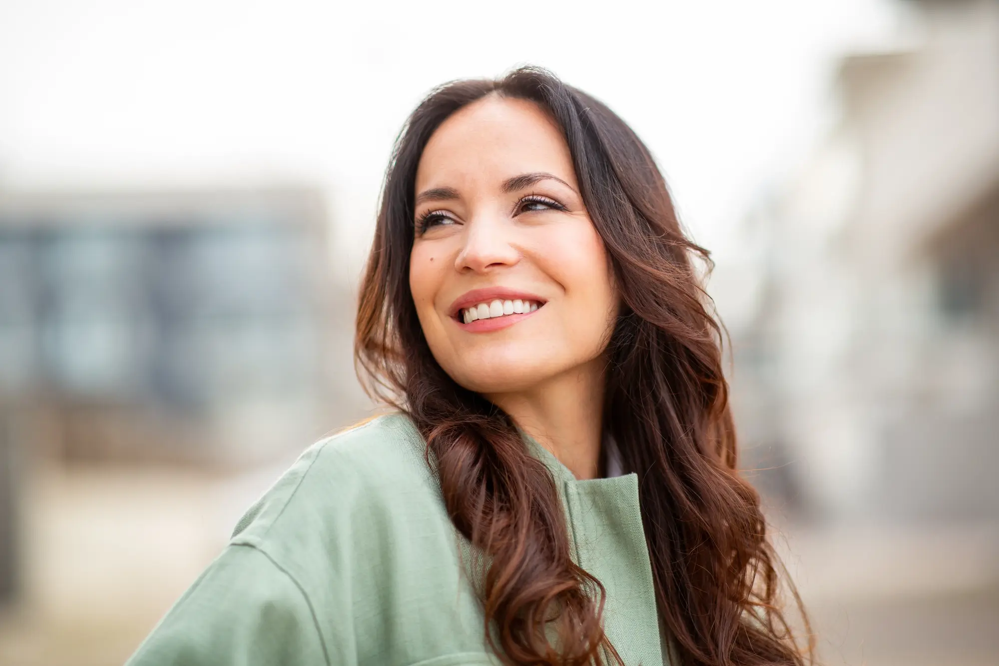 A woman smiling outdoors in the city