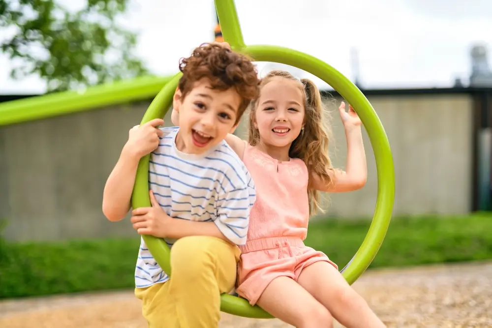 Two smiling children playing outdoors