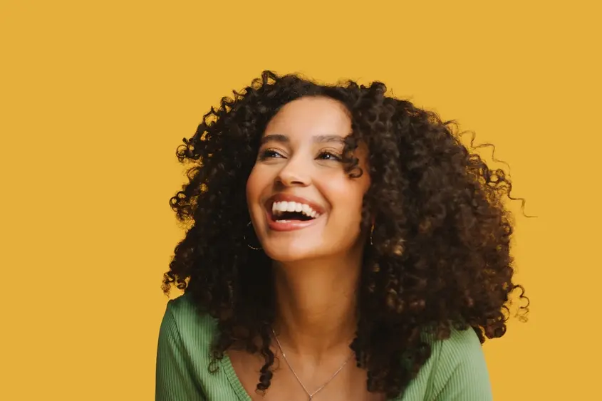Smiling woman against a yellow background